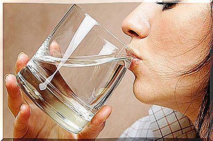 woman drinking water to eliminate bloating