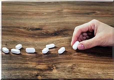 A hand laying medicine on a table. 